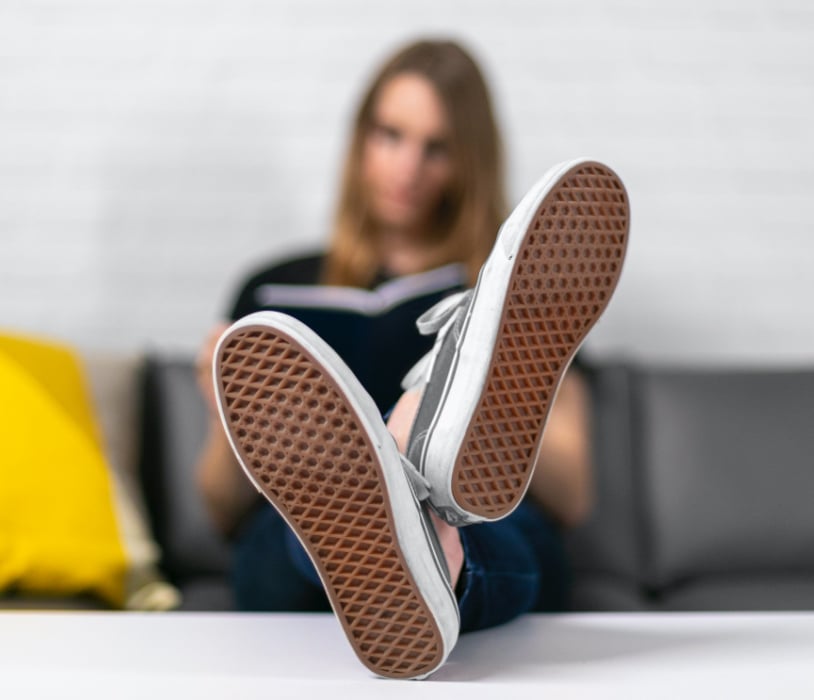 RentVision employee sitting on couch reading with feet up