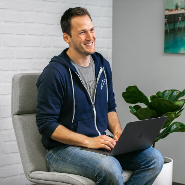 RentVision employee sitting on a chair with a laptop