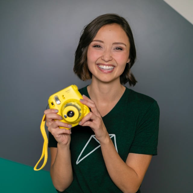 RentVision employee holding yellow polaroid camera