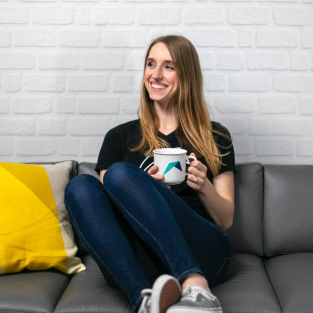 RentVision employee sitting on a couch with a coffee mug