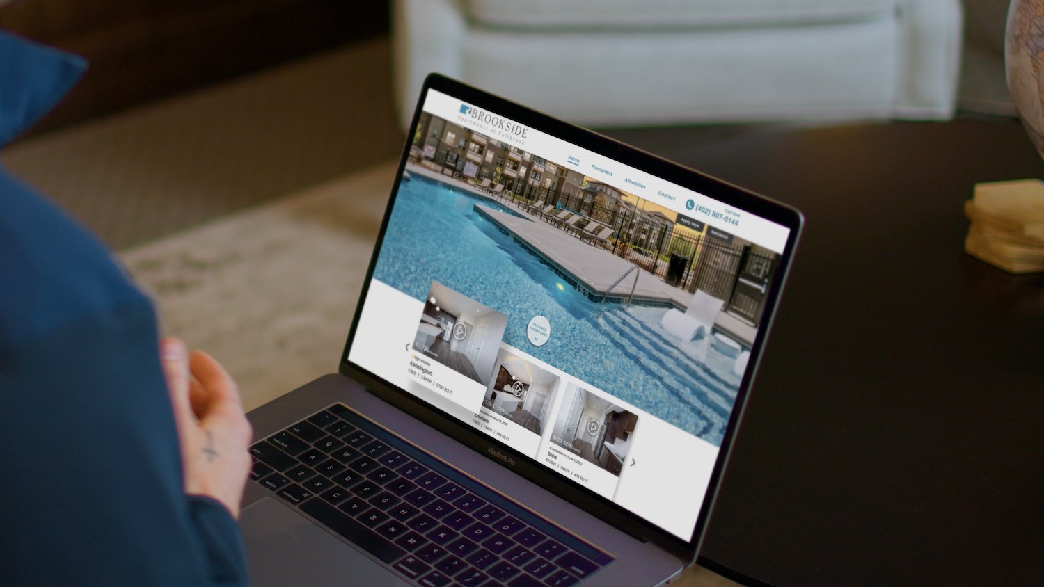 Person looking at an apartment community website on a laptop computer.