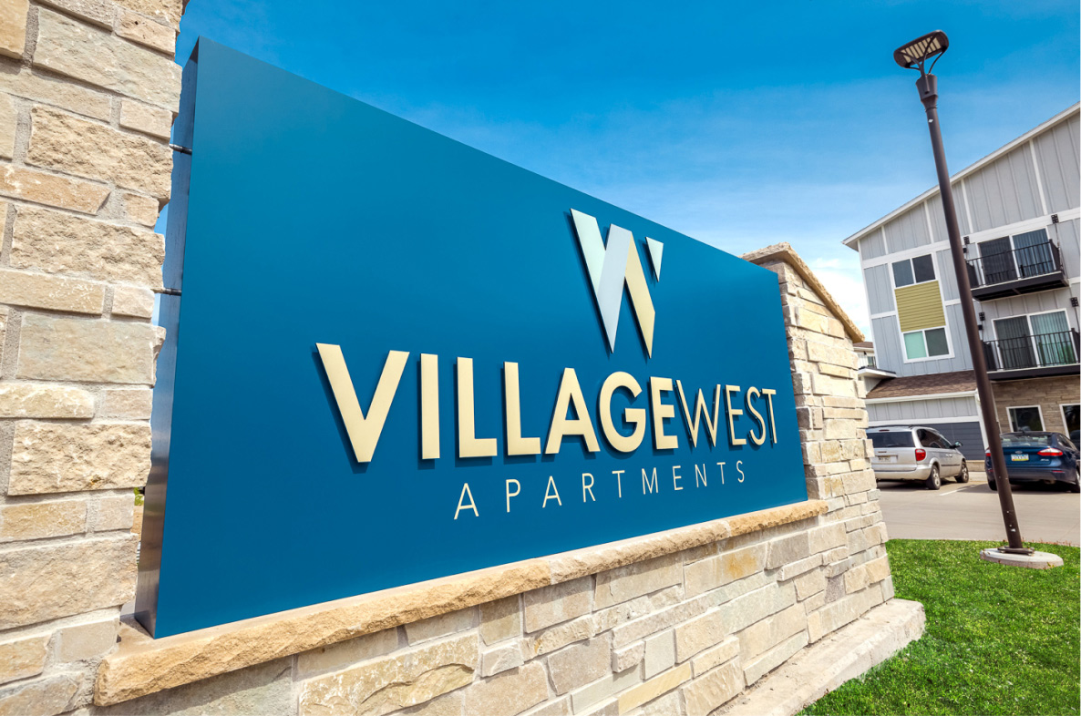Community signage for Village West Apartments.